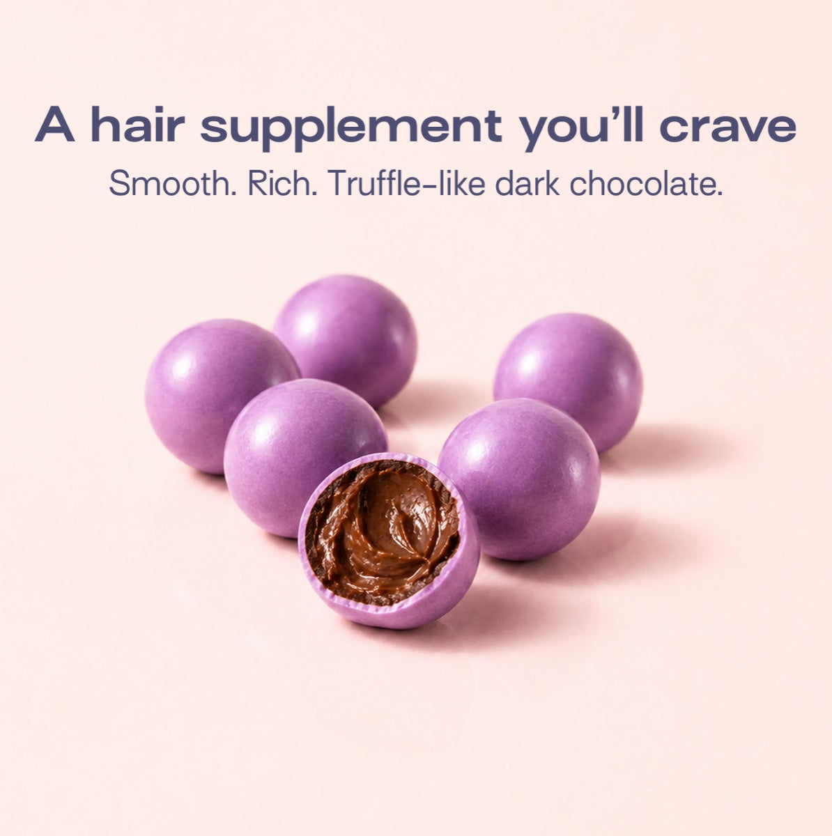 A hair supplement you will crave. Smooth, rich, truffle-like dark chocolate bites, one broken open.